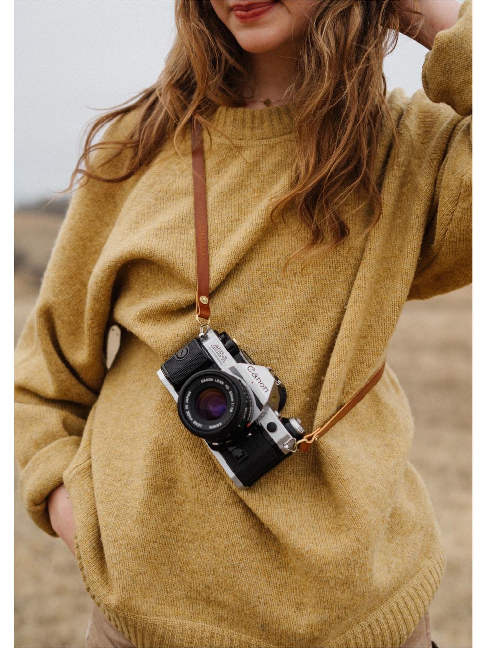 Girl wearing leather camera strap